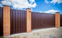 Откатные ворота из коричневого профнастила 2000х4000 мм с кирпичными столбами