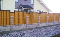 Деревянный забор на ленточном фундаменте и декоративными кирпичными столбами с отделкой камнем