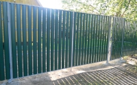 Забор из металлического штакетника темно-зеленого цвета с ровным верхом