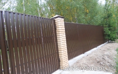 Забор из металлического штакетника с кирпичными столбами