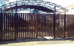Забор из металлического штакетника коричневого цвета и навес для машины