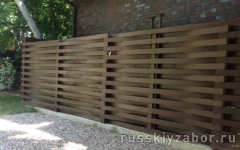 Деревянный забор Плетенка темно-коричневого цвета на металлических столбах
